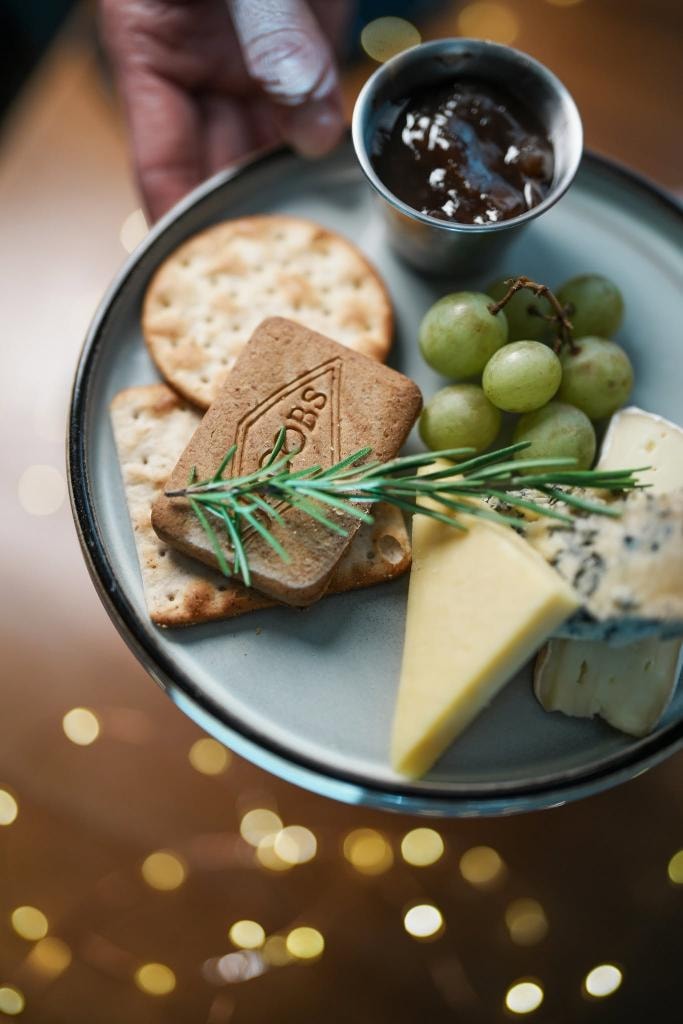 Cheese board with crackers and grapes